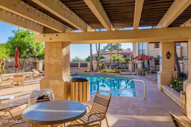 community pool with a patio area, a fenced backyard, and outdoor dining space