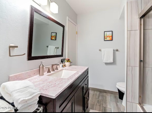 bathroom featuring vanity, wood-type flooring, and toilet