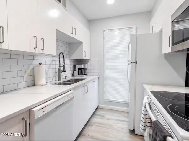 kitchen featuring white cabinetry, sink, and white dishwasher