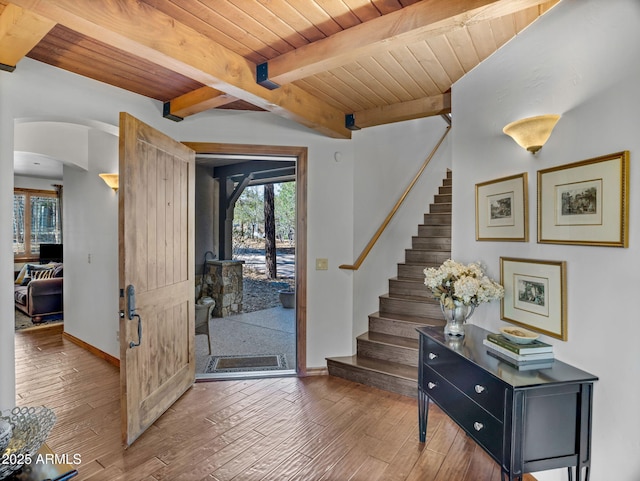 foyer entrance featuring wood ceiling, stairway, a wealth of natural light, and baseboards