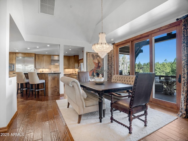 dining room with recessed lighting, a notable chandelier, dark wood-type flooring, visible vents, and lofted ceiling