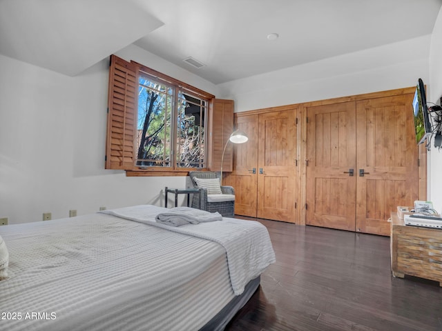 bedroom with dark wood-style floors and visible vents