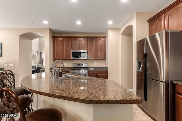 3693 E Sparrow Pl, Chandler, AZ 85286 - kitchen with stainless steel appliances, a sink, arched walkways, a breakfast bar, and recessed lighting