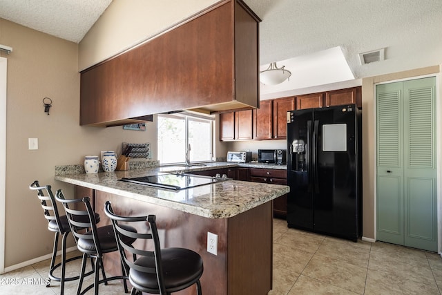 17802 N 45th Ave, Glendale, AZ 85308 - kitchen with a peninsula, a kitchen breakfast bar, a textured ceiling, custom range hood, and black appliances