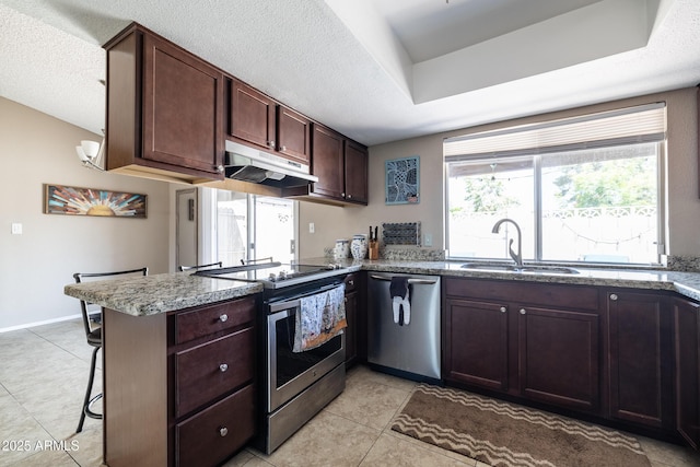 17802 N 45th Ave, Glendale, AZ 85308 - kitchen featuring a peninsula, light tile patterned flooring, under cabinet range hood, a sink, and appliances with stainless steel finishes