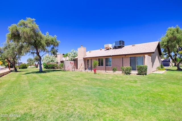17802 N 45th Ave, Glendale, AZ 85308 - rear view of house with fence, a chimney, a yard, and cooling unit