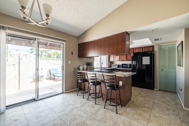 17802 N 45th Ave, Glendale, AZ 85308 - kitchen with a textured ceiling, visible vents, vaulted ceiling, black appliances, and a peninsula