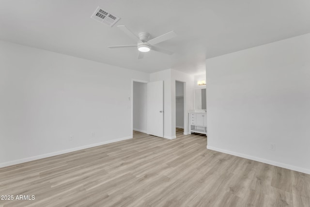 empty room with ceiling fan and light hardwood / wood-style flooring