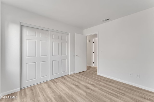 unfurnished bedroom featuring a closet and light hardwood / wood-style floors