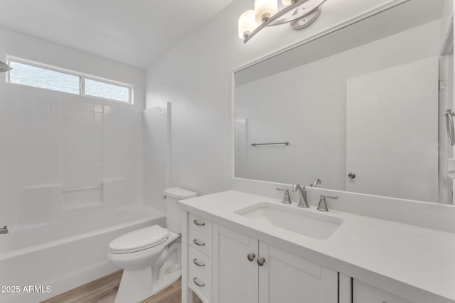 full bathroom featuring washtub / shower combination, vanity, hardwood / wood-style flooring, and toilet