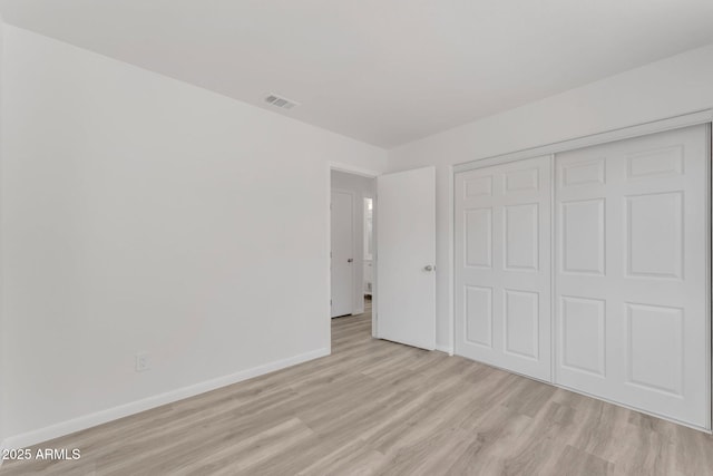 unfurnished bedroom with light hardwood / wood-style floors and a closet