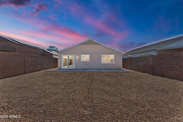 back house at dusk with a patio