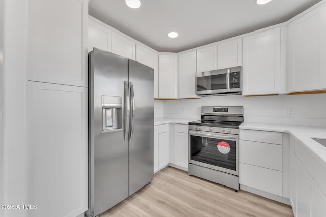 kitchen featuring white cabinets, light hardwood / wood-style floors, and appliances with stainless steel finishes