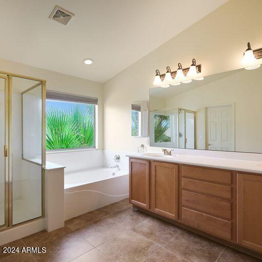 bathroom featuring vanity, tile patterned floors, separate shower and tub, and vaulted ceiling