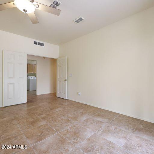 empty room featuring washer / dryer and ceiling fan