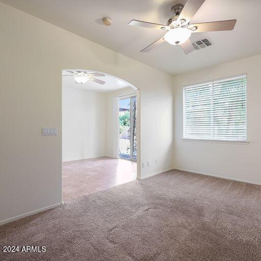 carpeted spare room featuring ceiling fan