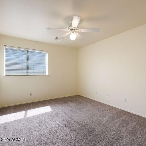 carpeted spare room with ceiling fan