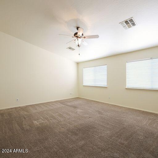 carpeted spare room with ceiling fan