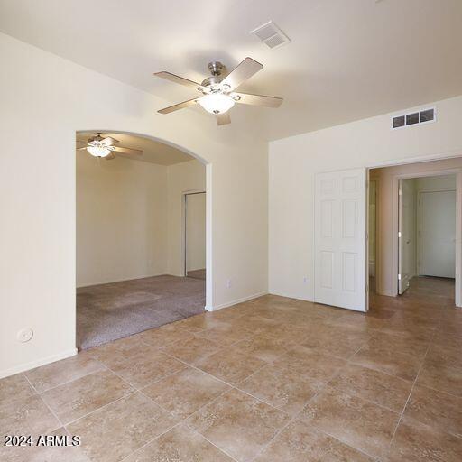 empty room with ceiling fan and light colored carpet