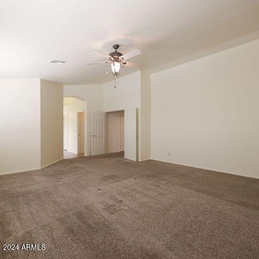 carpeted spare room featuring ceiling fan