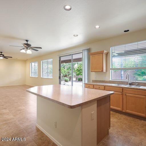 kitchen featuring a center island, ceiling fan, and sink