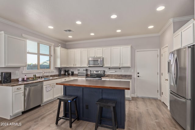 kitchen featuring butcher block counters, light wood-type flooring, white cabinetry, and appliances with stainless steel finishes