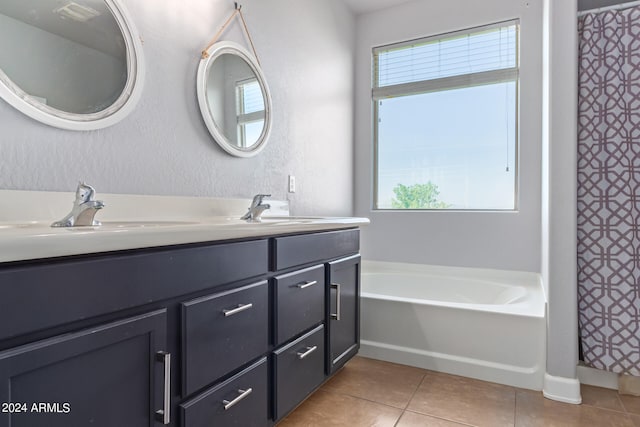 bathroom featuring tile patterned floors, a tub, and vanity