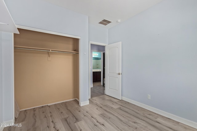 unfurnished bedroom with a closet and light wood-type flooring