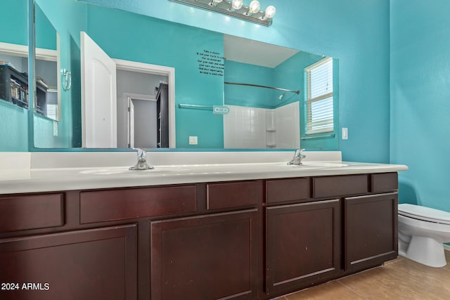 bathroom with tile patterned floors, a shower, vanity, and toilet