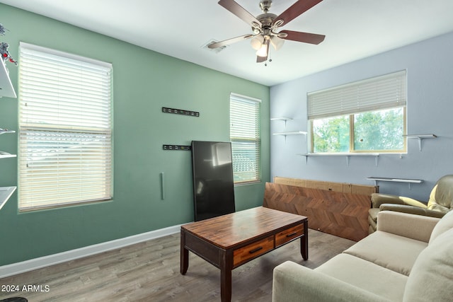 living room featuring hardwood / wood-style flooring, ceiling fan, and a healthy amount of sunlight