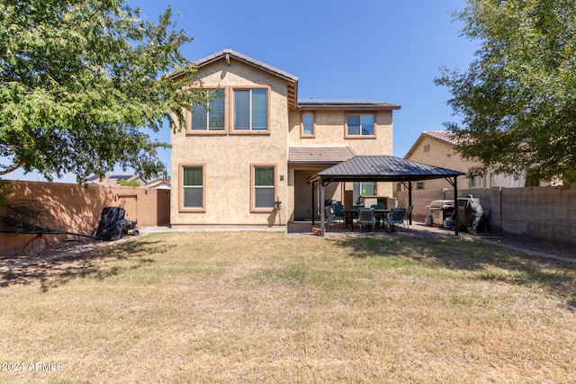 rear view of property with a gazebo and a yard