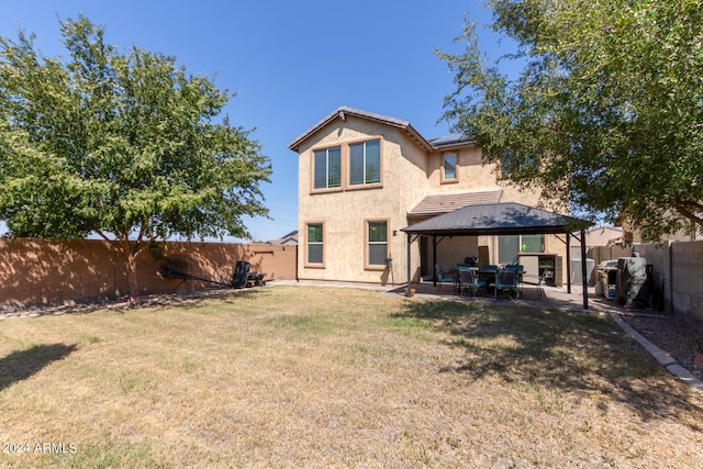 back of property with a gazebo and a yard