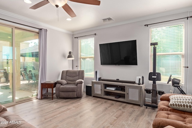 living room featuring light hardwood / wood-style floors, a wealth of natural light, ornamental molding, and ceiling fan