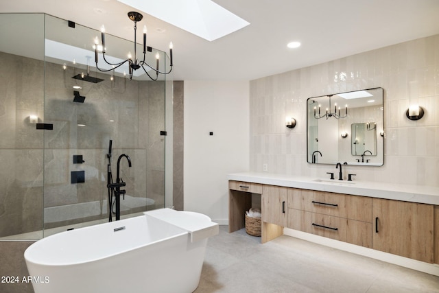 bathroom featuring a skylight, tile walls, vanity, and plus walk in shower