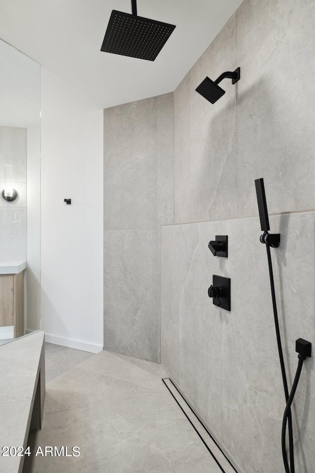 bathroom featuring tiled shower, vanity, and tile walls