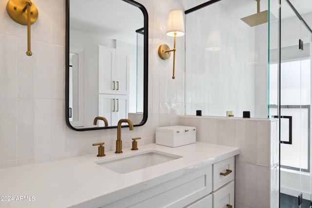 bathroom with vanity, tile walls, and a shower with door