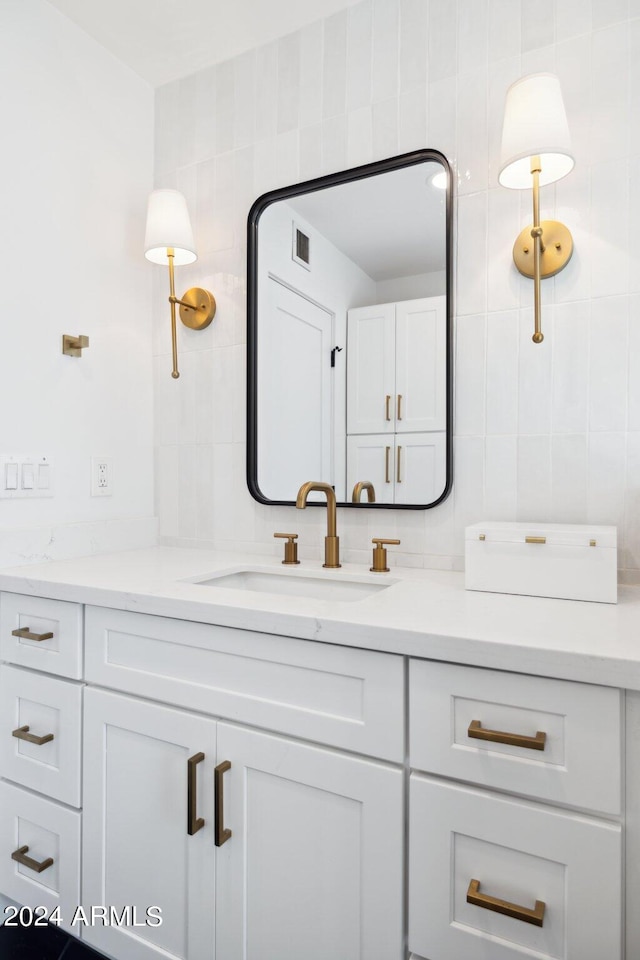 bathroom with tile walls, vanity, and backsplash