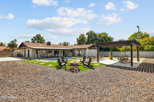 rear view of house with a pergola, a patio, and a fenced in pool