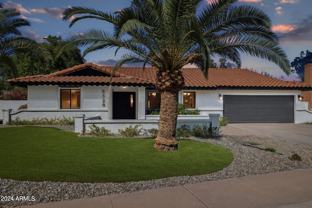 mediterranean / spanish house featuring a yard and a garage