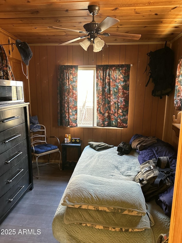 bedroom with wood walls, wood ceiling, and dark wood-style flooring