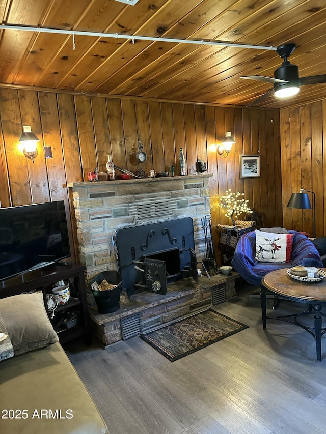 living area with a ceiling fan, wooden ceiling, and wood finished floors