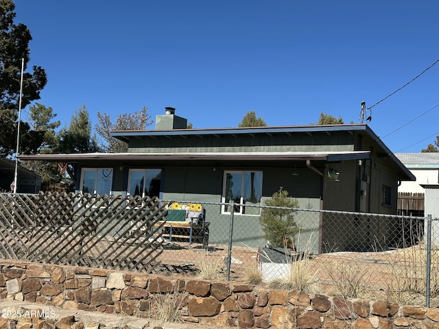 view of front facade with a fenced front yard and a chimney