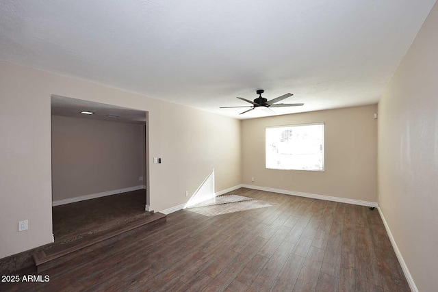 empty room featuring dark wood-type flooring and ceiling fan