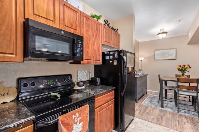 kitchen with black appliances and light hardwood / wood-style flooring