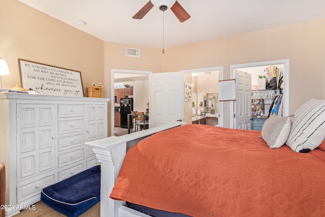 carpeted bedroom with a closet, black refrigerator, ensuite bath, a spacious closet, and ceiling fan