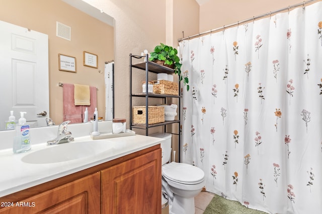 bathroom with vanity, toilet, and tile patterned floors