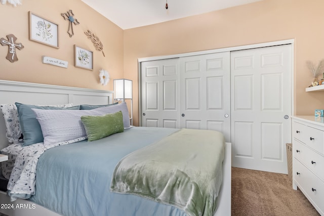 carpeted bedroom featuring a closet and lofted ceiling