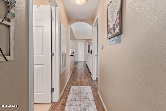 corridor with hardwood / wood-style flooring