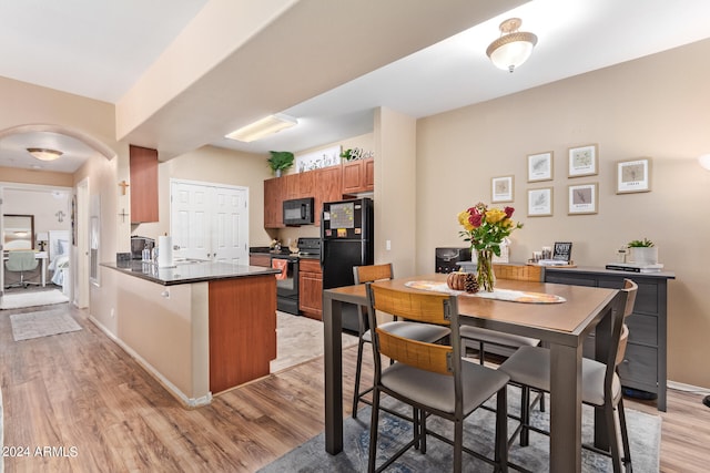 kitchen featuring black appliances, light hardwood / wood-style flooring, and kitchen peninsula