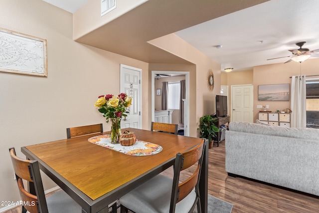 dining area with dark wood-type flooring and ceiling fan